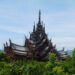 A photo of The Sanctuary of Truth in Pattaya in Thailand. The whole temple is made out of wood in a beautiful setting of beach and trees.